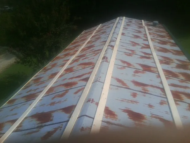 Rusted metal roof panels with new wood purlins before replacement — Storm Damage Roof Repair in Pelzer by Roofing Brothers