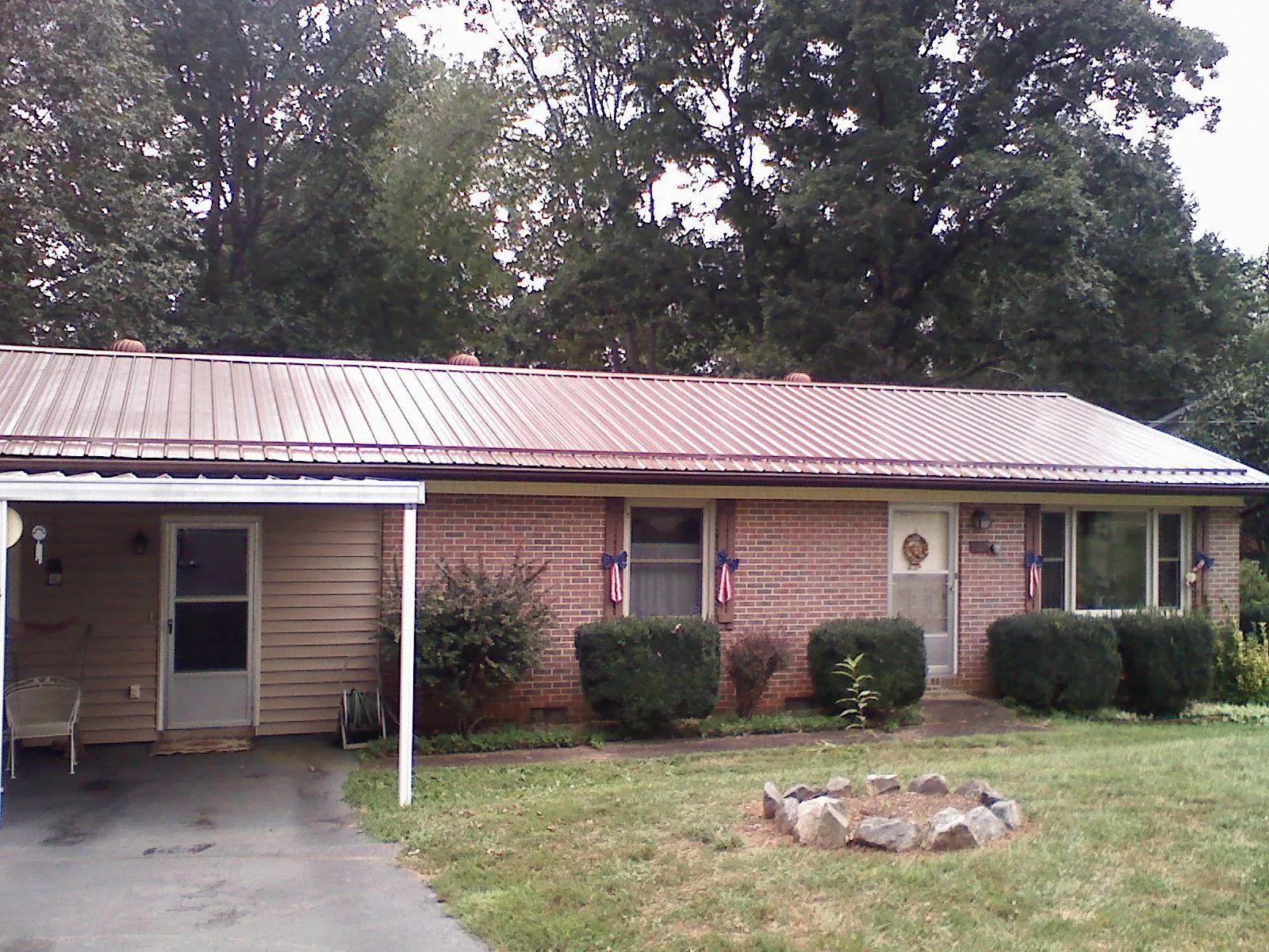 Bronze metal roof and carport on a brick ranch home — Roof Repair work by our crew in Pelzer
